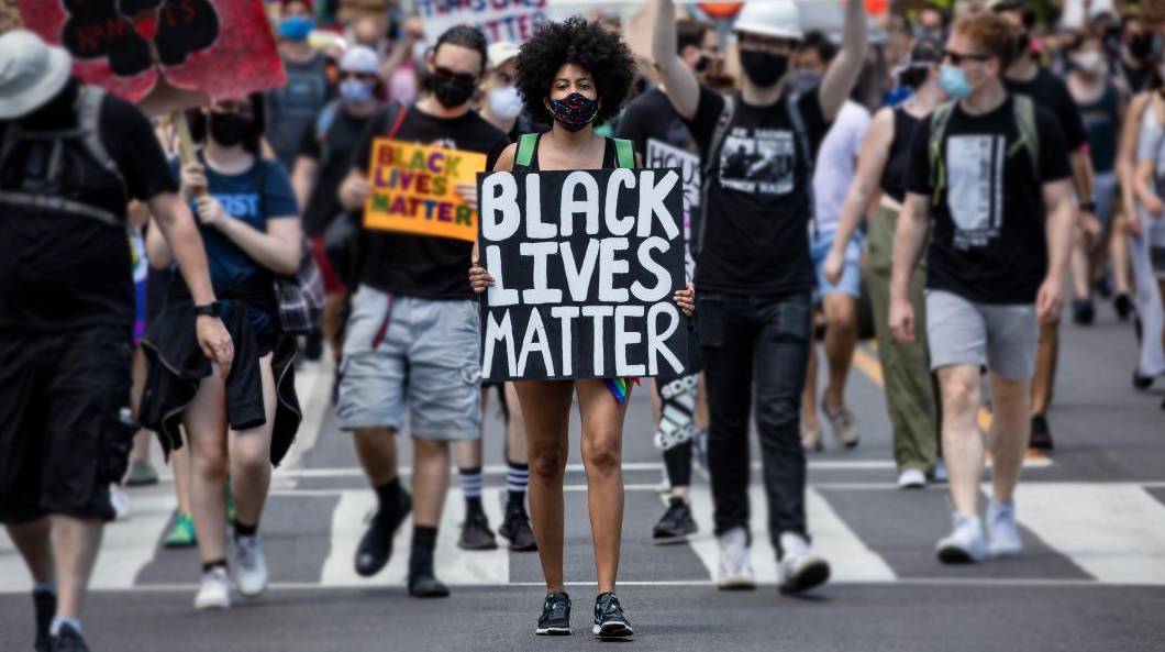 young woman marching with black lives matter sign